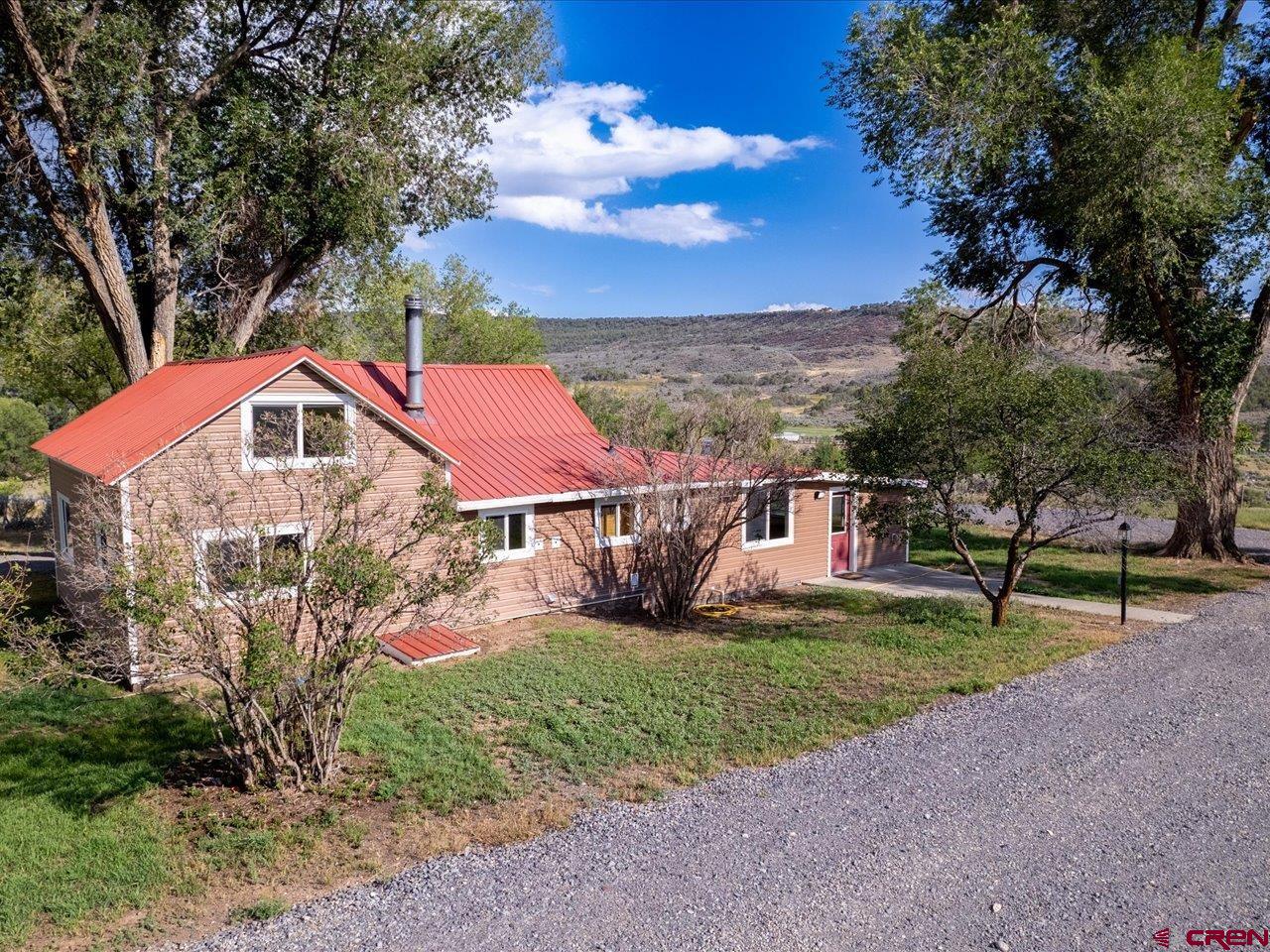 27434 Cedar Mesa Road Cedaredge, CO 81413 - Photo 7 of 36 a view of a house with a yard and sitting area