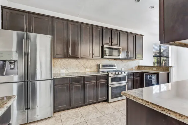a kitchen with stainless steel appliances granite countertop a refrigerator stove and microwave
