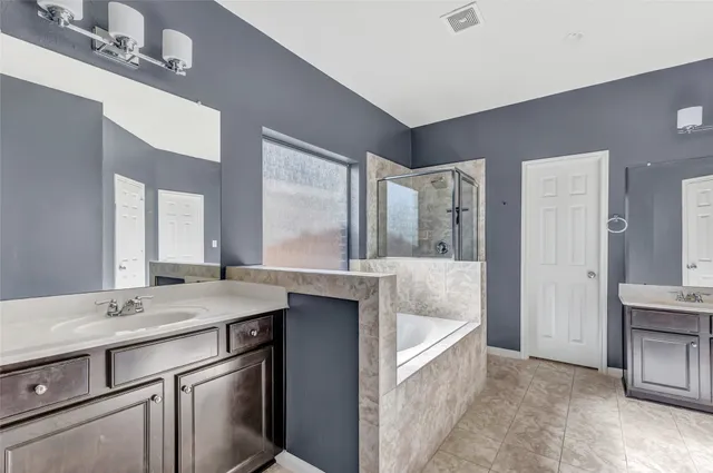 a bathroom with a granite countertop sink mirror and bathtub