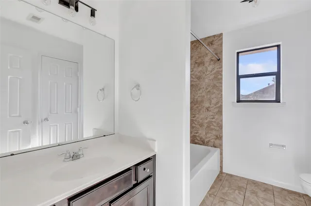 a bathroom with a tub sink and vanity