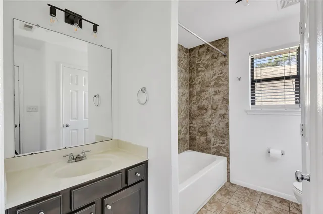 a bathroom with a tub sink and mirror