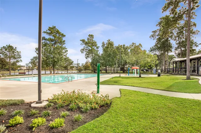 a view of a fountain in front of a house with a big yard