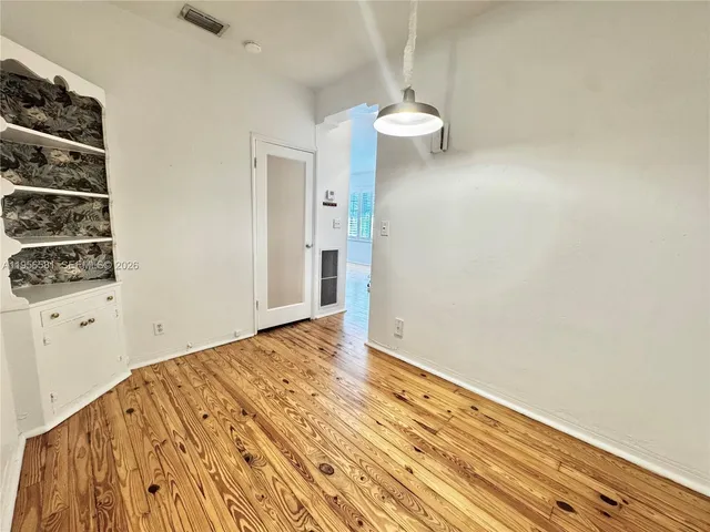 a view of a room with wooden floor and white walls