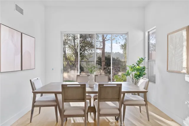 a dining room with furniture window and wooden floor