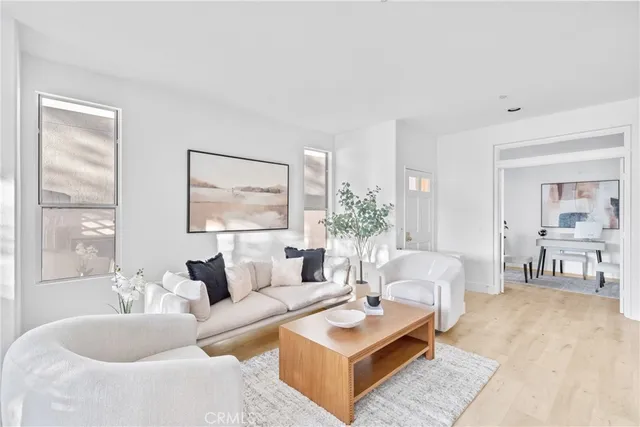 a living room with furniture and a dining table with wooden floor
