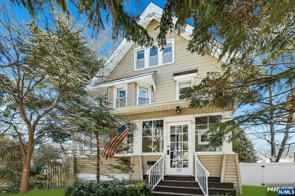 a front view of a building with a tree