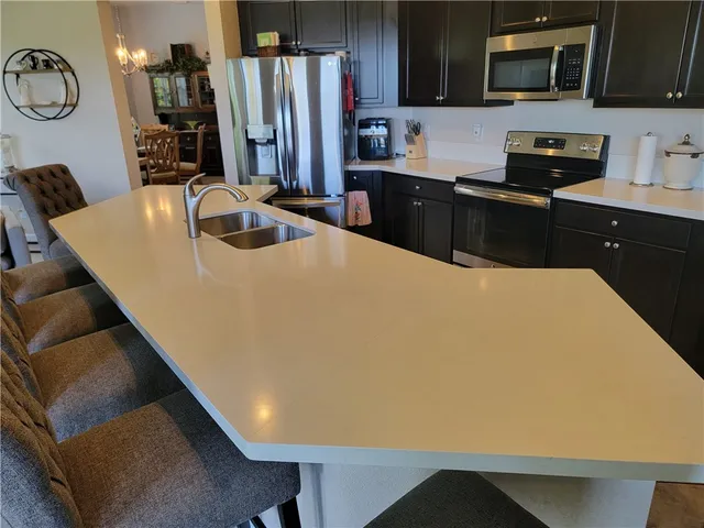 a kitchen with stainless steel appliances a refrigerator sink and stove