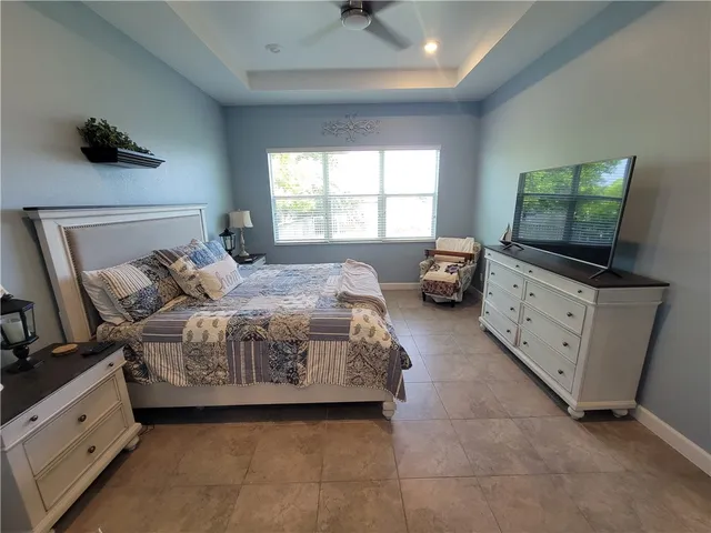 a bedroom with a bed and a flat tv screen on dresser