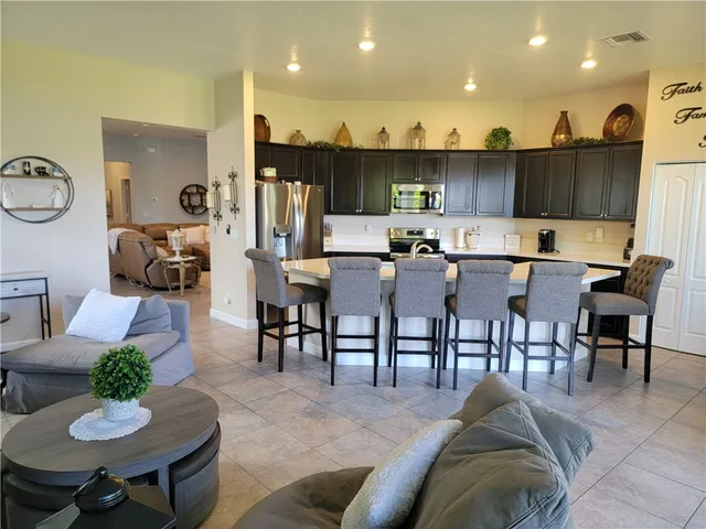 a living room with lots of furniture and kitchen view