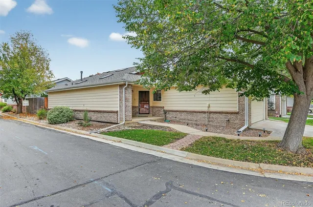 a front view of a house with garage and plants