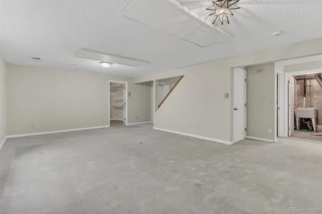 an empty room with windows and fireplace