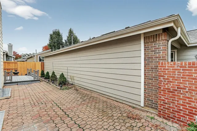 a backyard of a house with wooden floor chairs and wooden fence