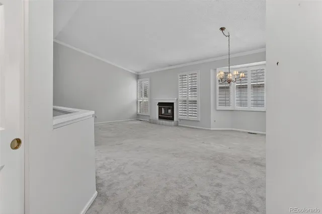 an empty room with windows and fireplace