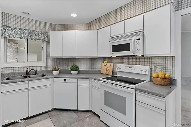 a kitchen with white cabinets and white appliances