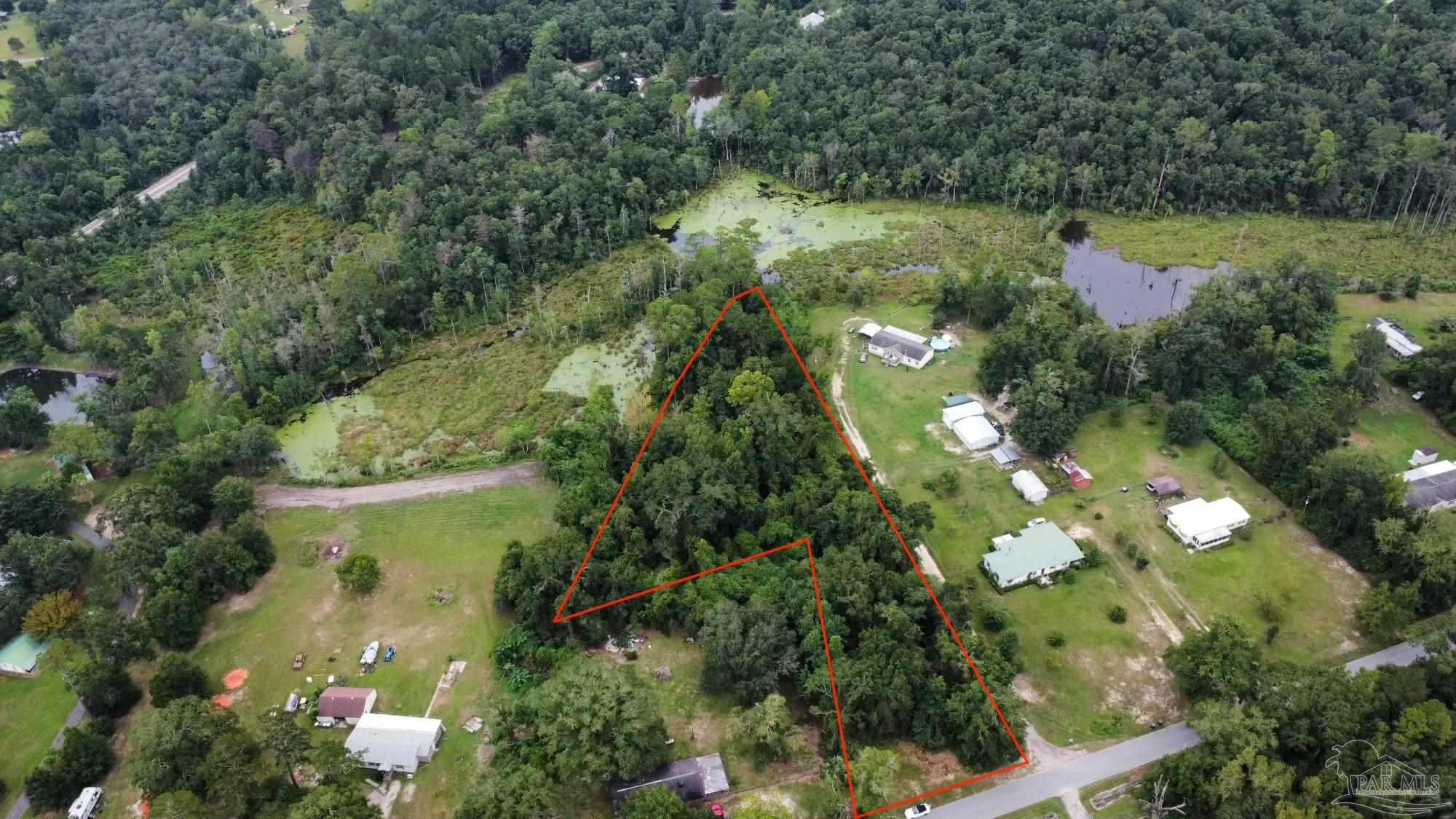 6400 Fairground Road Molino, FL 32577 - Photo 3 of 4 a view of a garden with a lake