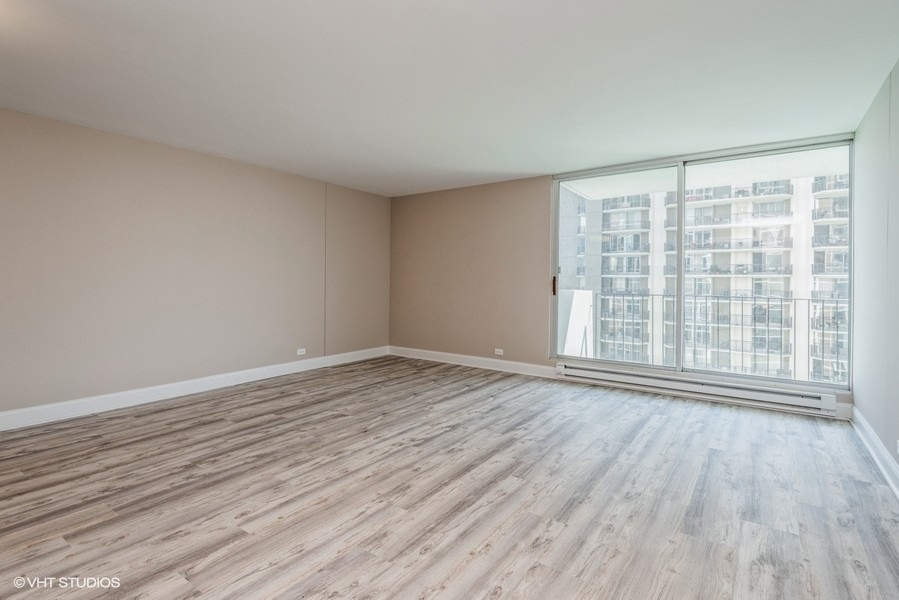 6033 North Sheridan Road, Unit 31E Chicago, IL 60660 - Photo 3 of 15 wooden floor in an empty room with a window