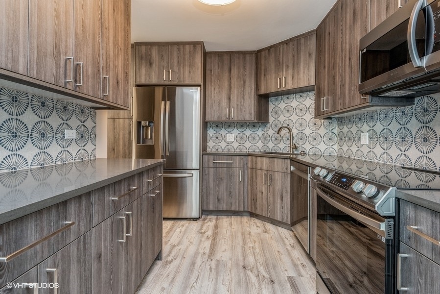6033 North Sheridan Road, Unit 31E Chicago, IL 60660 - Photo 6 of 15 a kitchen with stainless steel appliances granite countertop a refrigerator microwave and sink