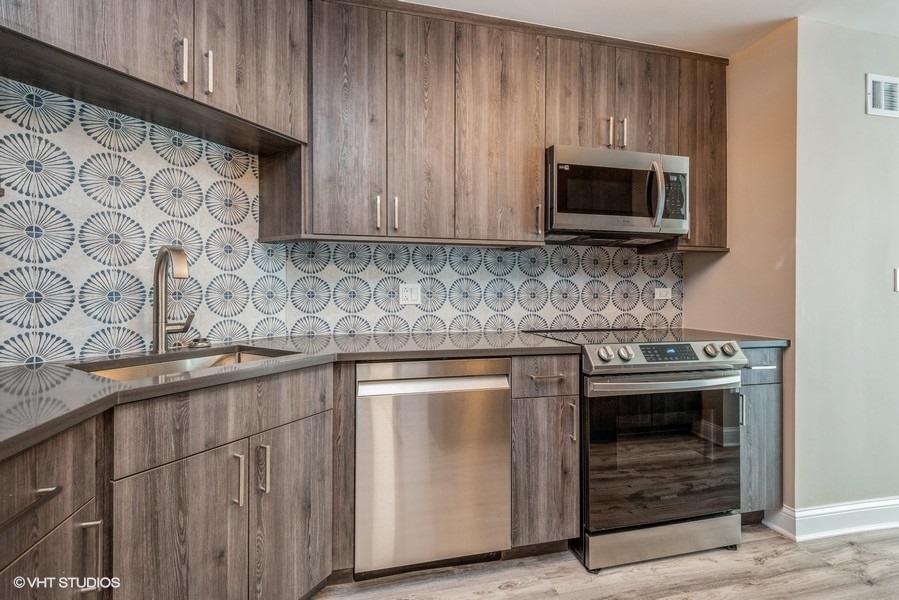 6033 North Sheridan Road, Unit 31E Chicago, IL 60660 - Photo 7 of 15 a kitchen with stainless steel appliances granite countertop a stove and a microwave