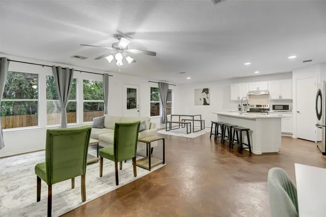 a living room with furniture and kitchen view