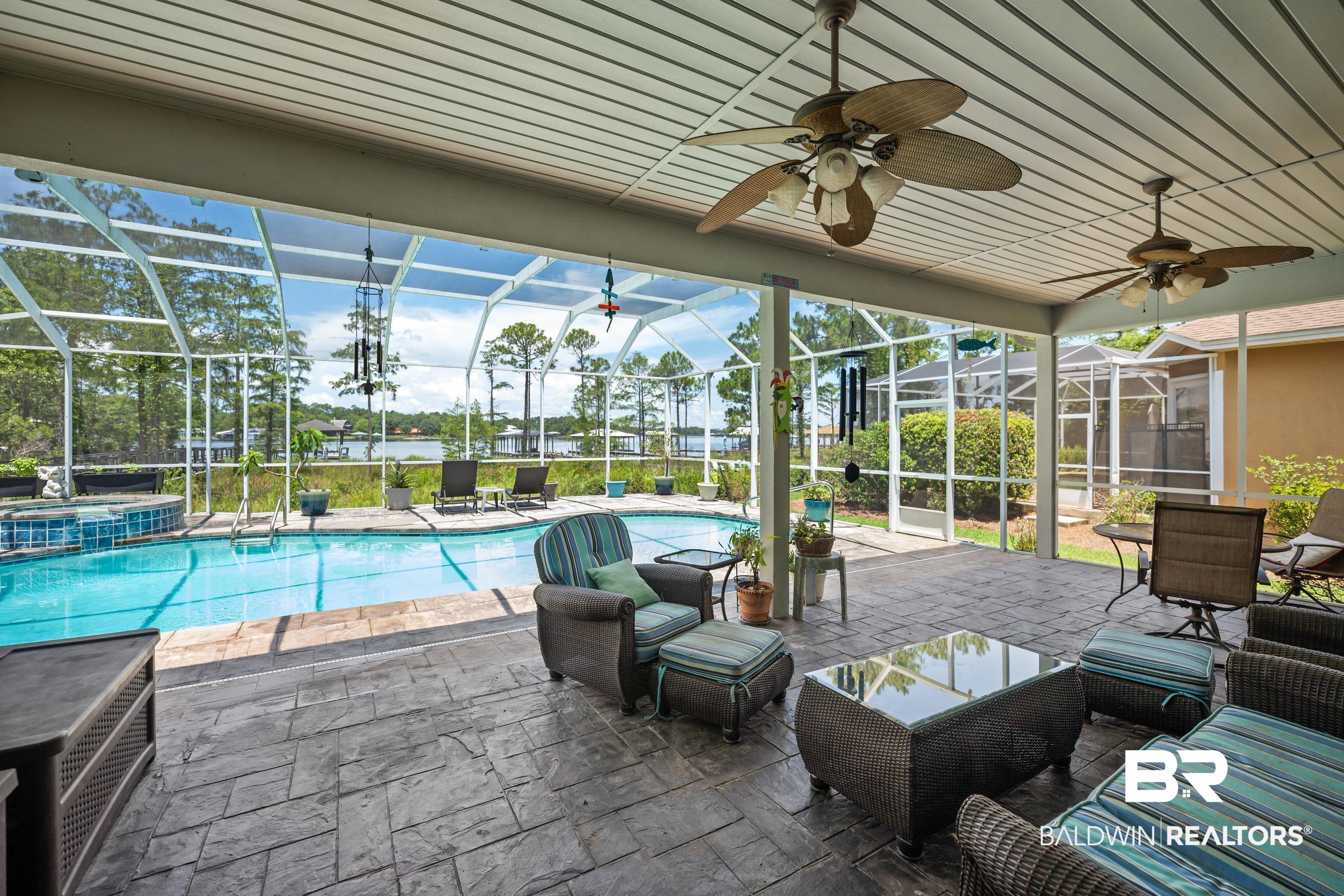 8585 Bay Harbor Road Elberta, AL 36530 - Photo 35 of 51 View of swimming pool with glass enclosure, a patio, a pool with connected hot tub, and ceiling fan