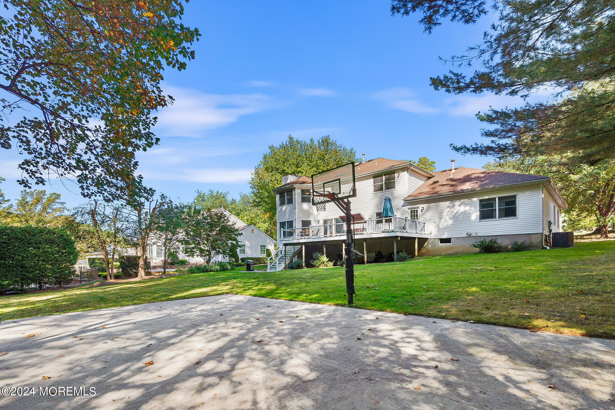 276 Nottingham Road Morganville, NJ 07751 - Photo 52 of 55 a view of a white house with a big yard and potted plants and large trees