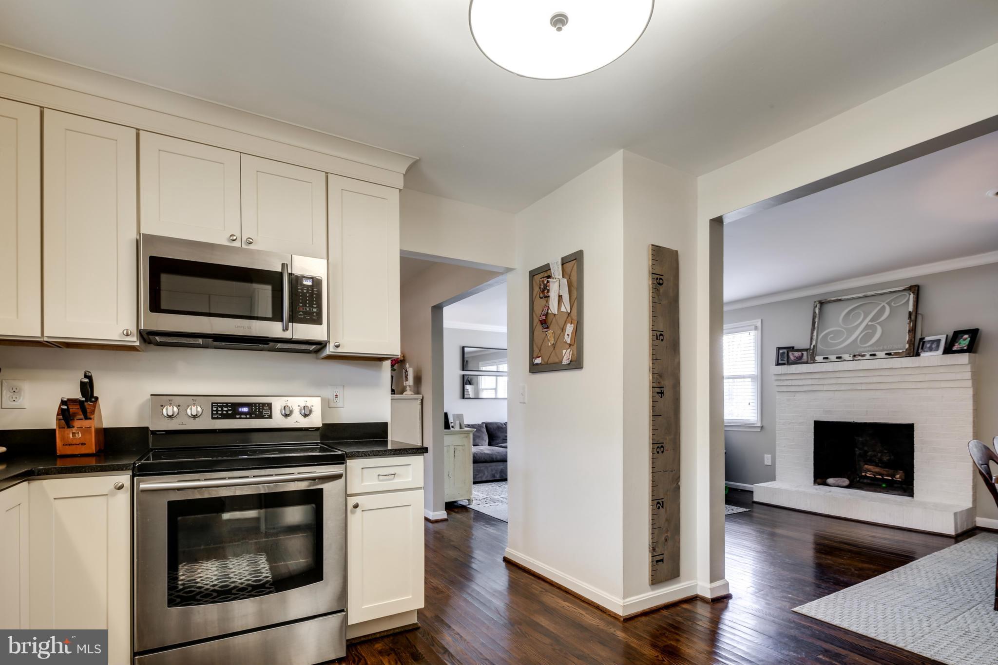 a kitchen with stainless steel appliances granite countertop a stove a microwave and a hard wood floors