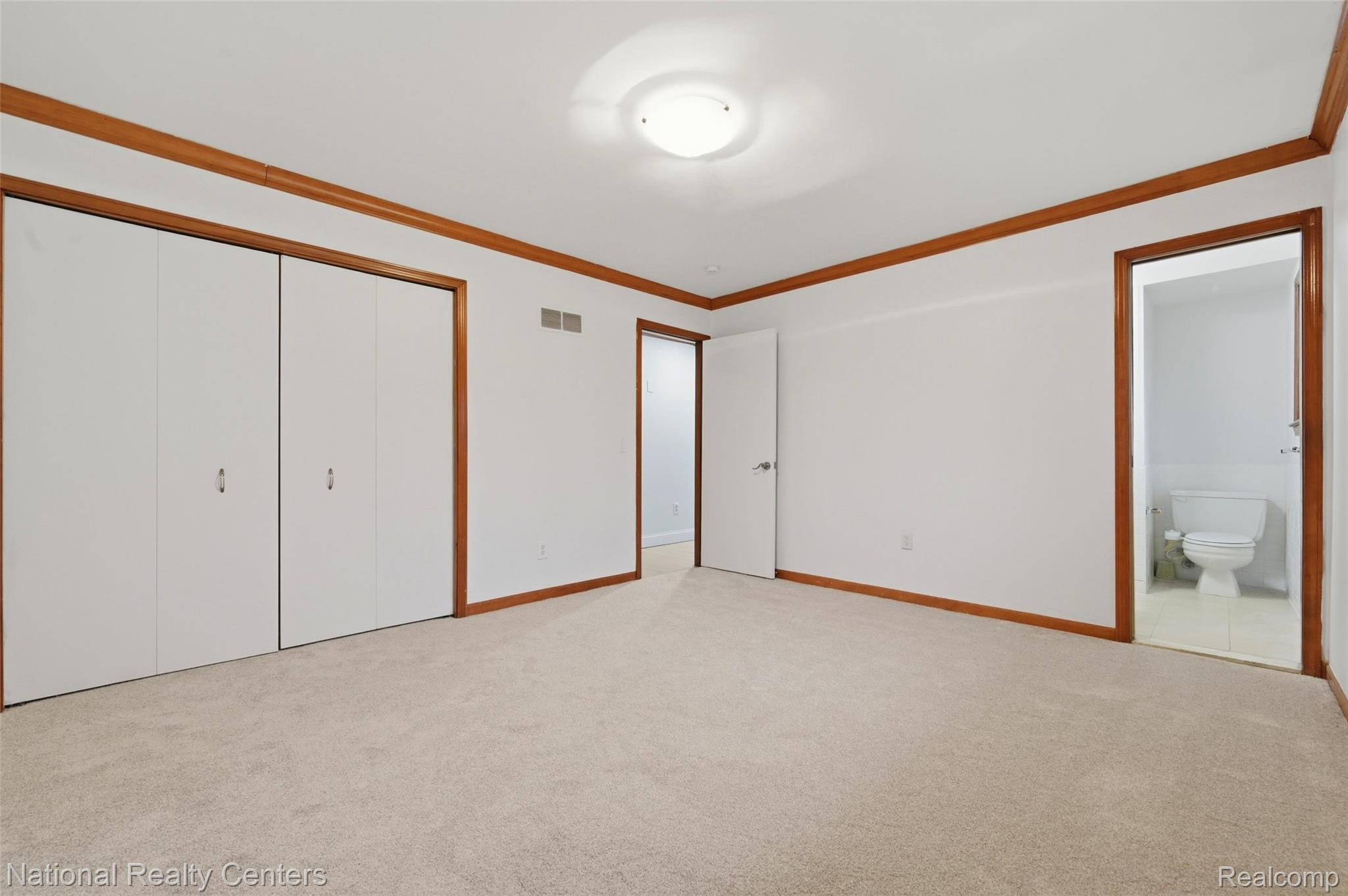 37625 Ryan Road Sterling Heights, MI 48310 - Photo 19 of 30 Unfurnished bedroom featuring light carpet, crown molding, a closet, and ensuite bath