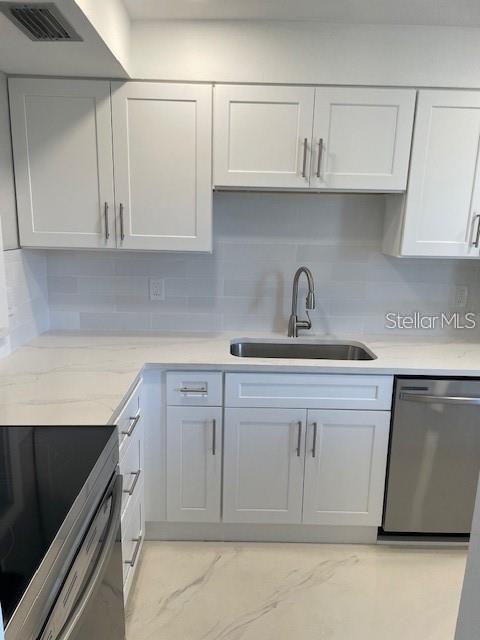 1 Boca Ciega Point Boulevard, Unit 115 St. Petersburg, FL 33708 - Photo 6 of 35 a kitchen with white cabinets and a sink