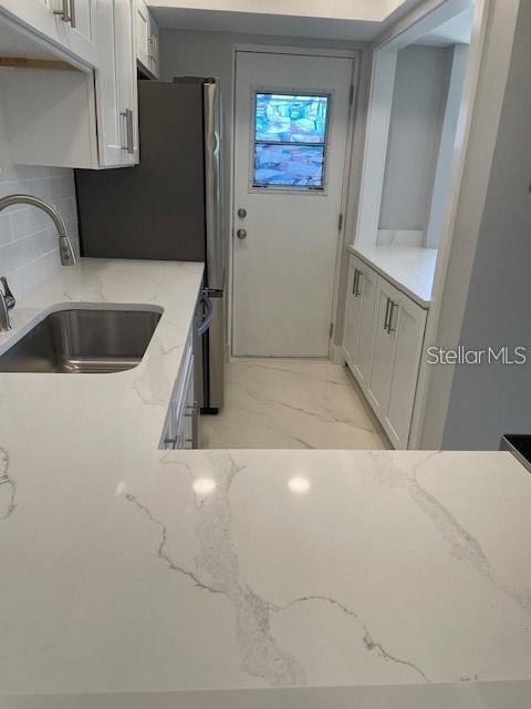 1 Boca Ciega Point Boulevard, Unit 115 St. Petersburg, FL 33708 - Photo 7 of 35 a kitchen with a sink a refrigerator and cabinets
