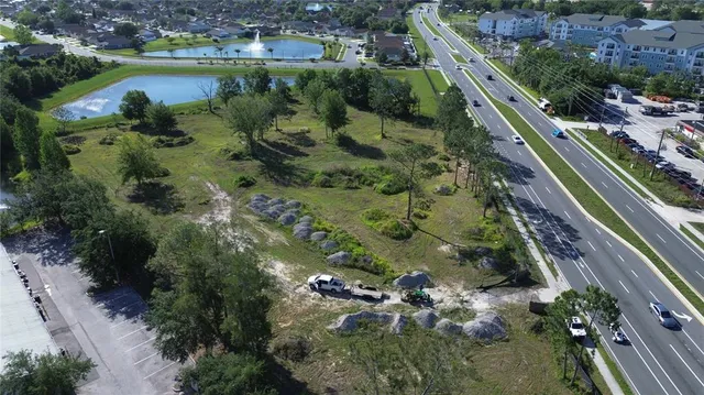 an aerial view of residential houses with outdoor space and lake view