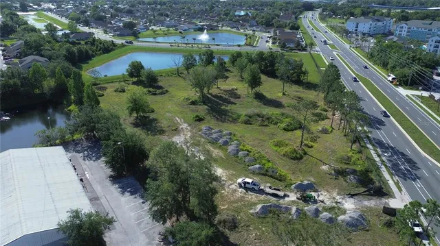 an aerial view of residential houses with outdoor space and trees