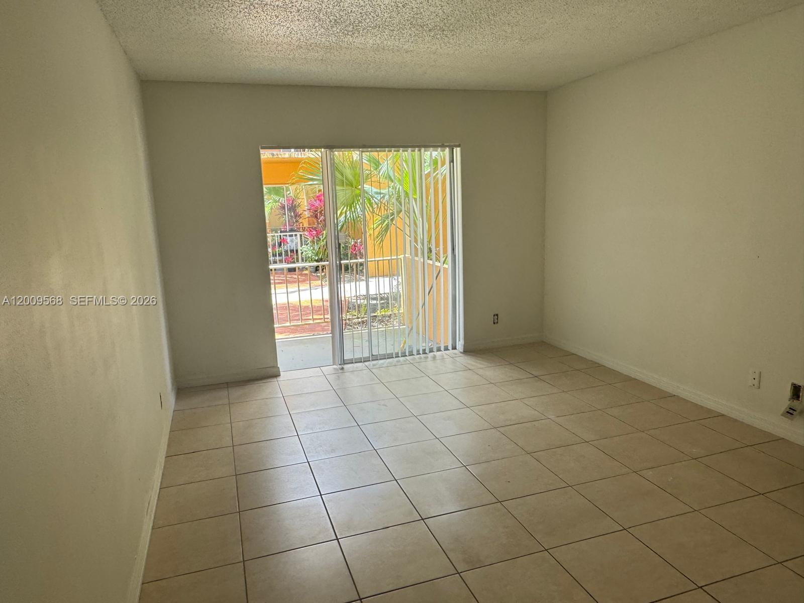 18111 Northwest 68th Avenue, Unit F106 Hialeah, FL 33015 - Photo 1 of 10 a view of an empty room with a window