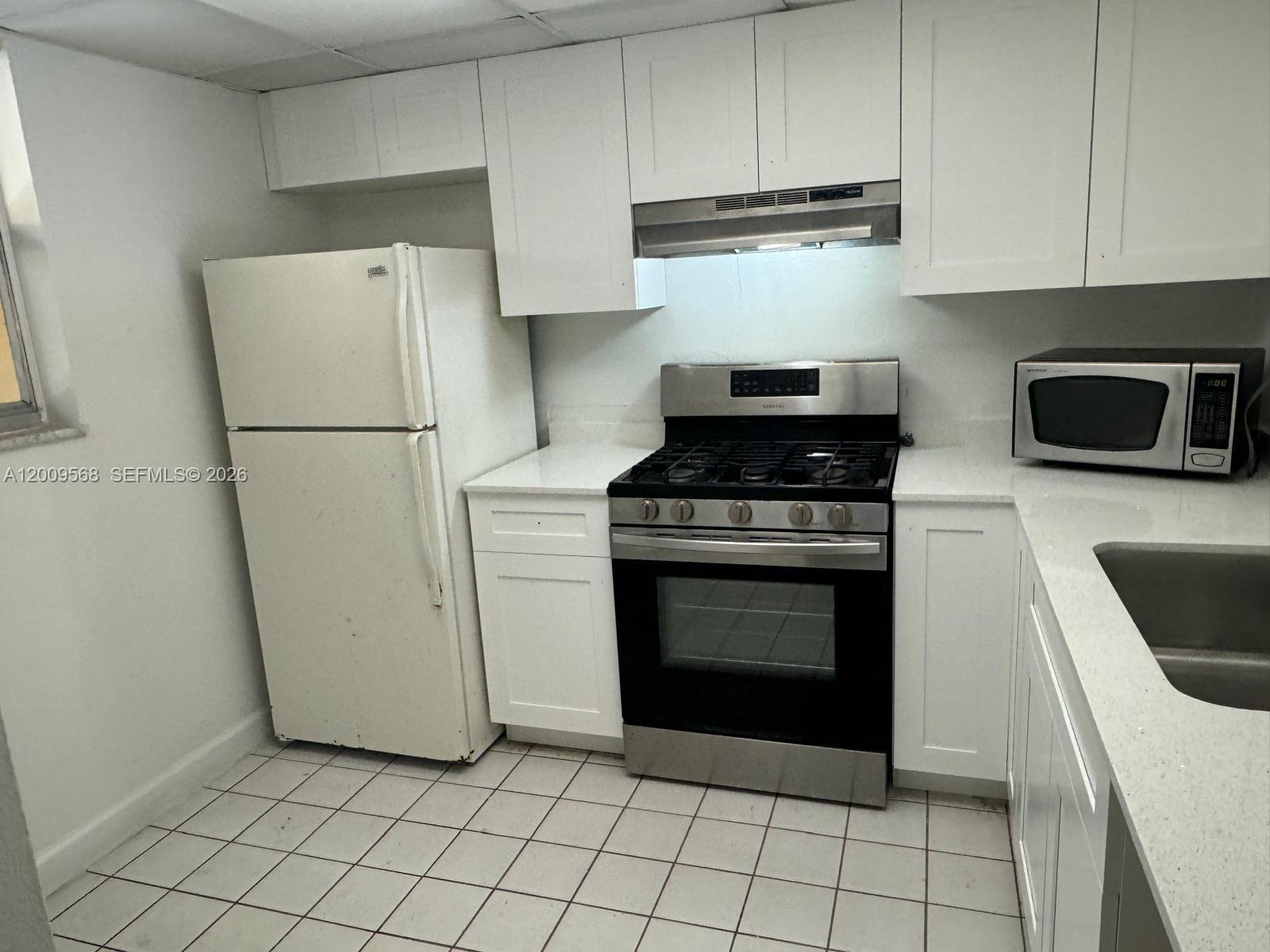 18111 Northwest 68th Avenue, Unit F106 Hialeah, FL 33015 - Photo 3 of 10 a kitchen with cabinets and steel stainless steel appliances