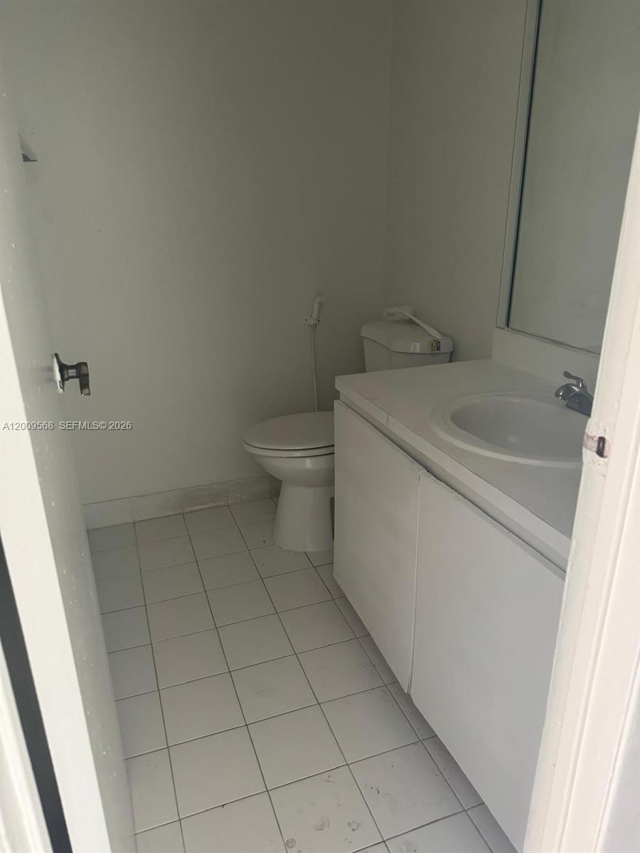 18111 Northwest 68th Avenue, Unit F106 Hialeah, FL 33015 - Photo 6 of 10 a bathroom with a sink and toilet