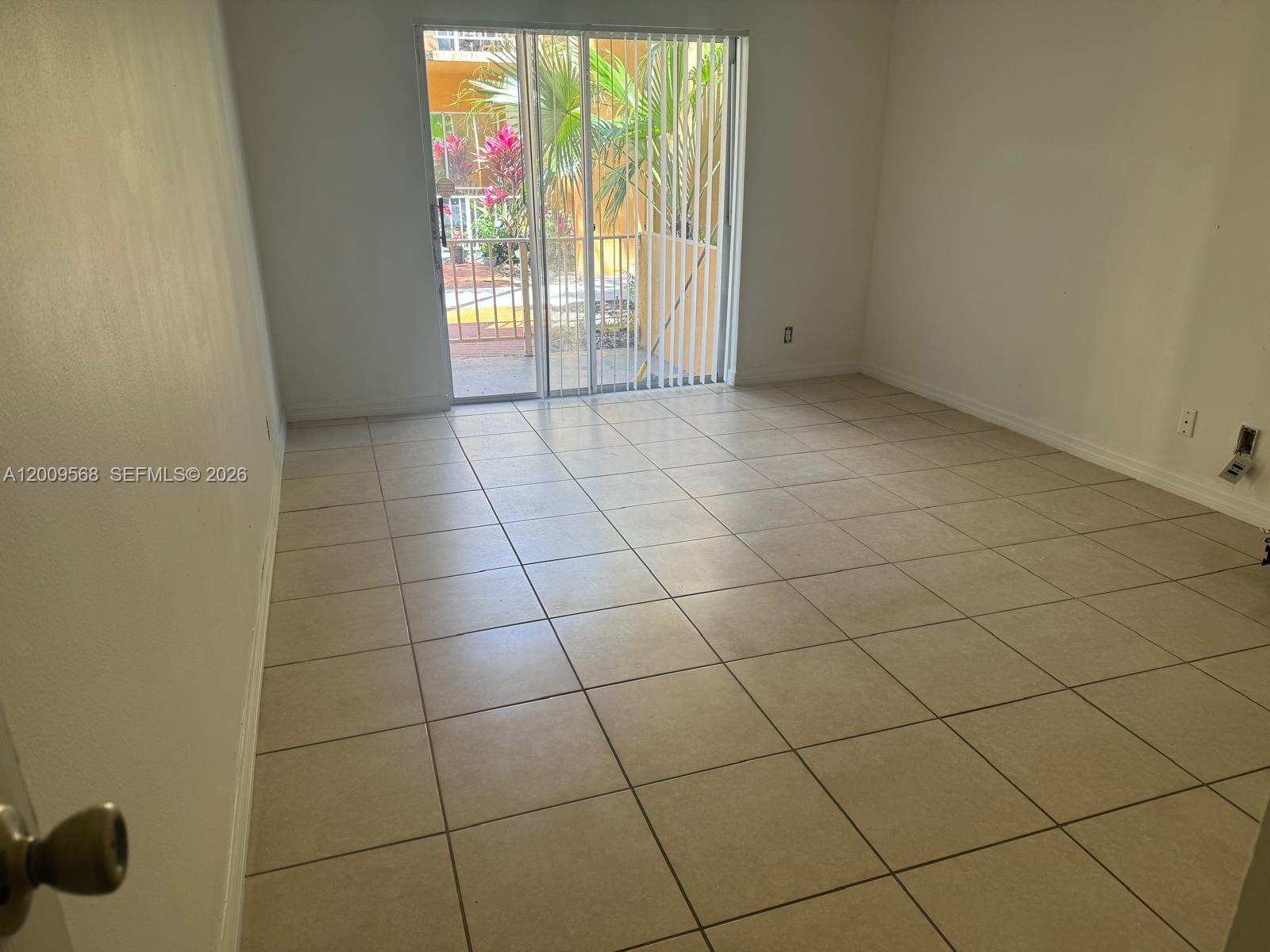 18111 Northwest 68th Avenue, Unit F106 Hialeah, FL 33015 - Photo 7 of 10 a view of an empty room and window