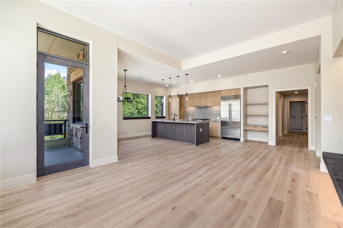 75 Hunki Dori Court, Unit W113 Keystone, CO 80435 - Photo 12 of 50 a view of an empty room with wooden floor and a kitchen