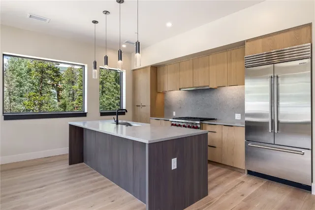 a kitchen with stainless steel appliances granite countertop a sink a stove and a refrigerator