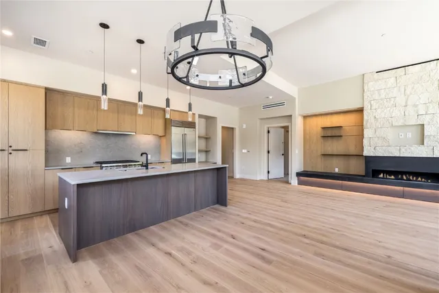 a kitchen with stainless steel appliances granite countertop a sink a stove and a wooden floors