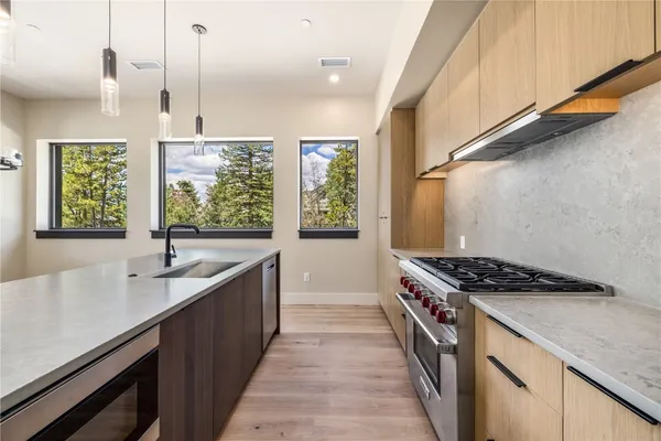 a kitchen with kitchen island stainless steel appliances a sink stove and cabinets