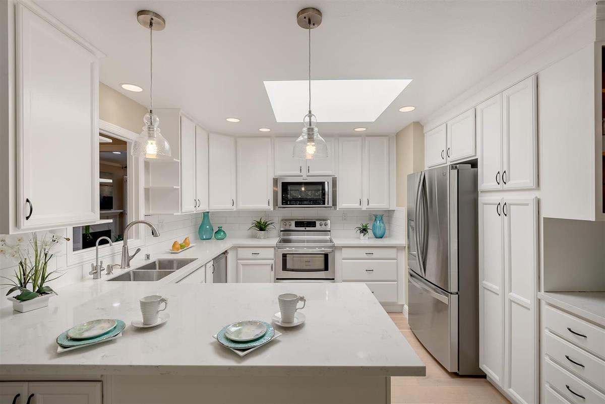 23030 Stonebridge Cupertino, CA 95014 - Photo 12 of 26 a kitchen with stainless steel appliances kitchen island granite countertop a refrigerator a sink a stove a dining table and chairs