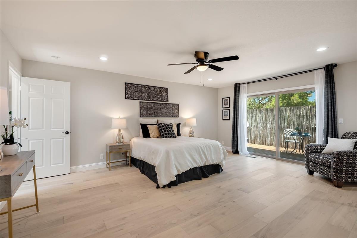 23030 Stonebridge Cupertino, CA 95014 - Photo 15 of 26 a spacious bedroom with a bed a couch and a ceiling fan