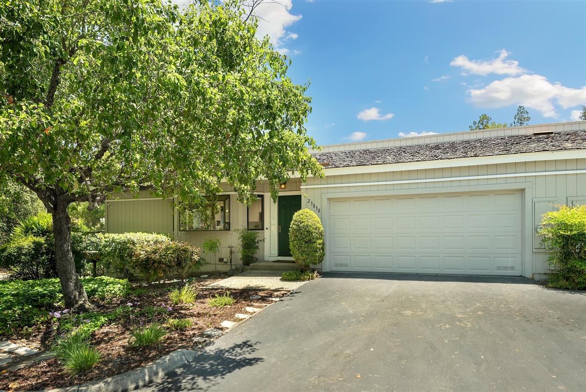 23030 Stonebridge Cupertino, CA 95014 - Photo 2 of 26 a front view of a house with a yard and garage