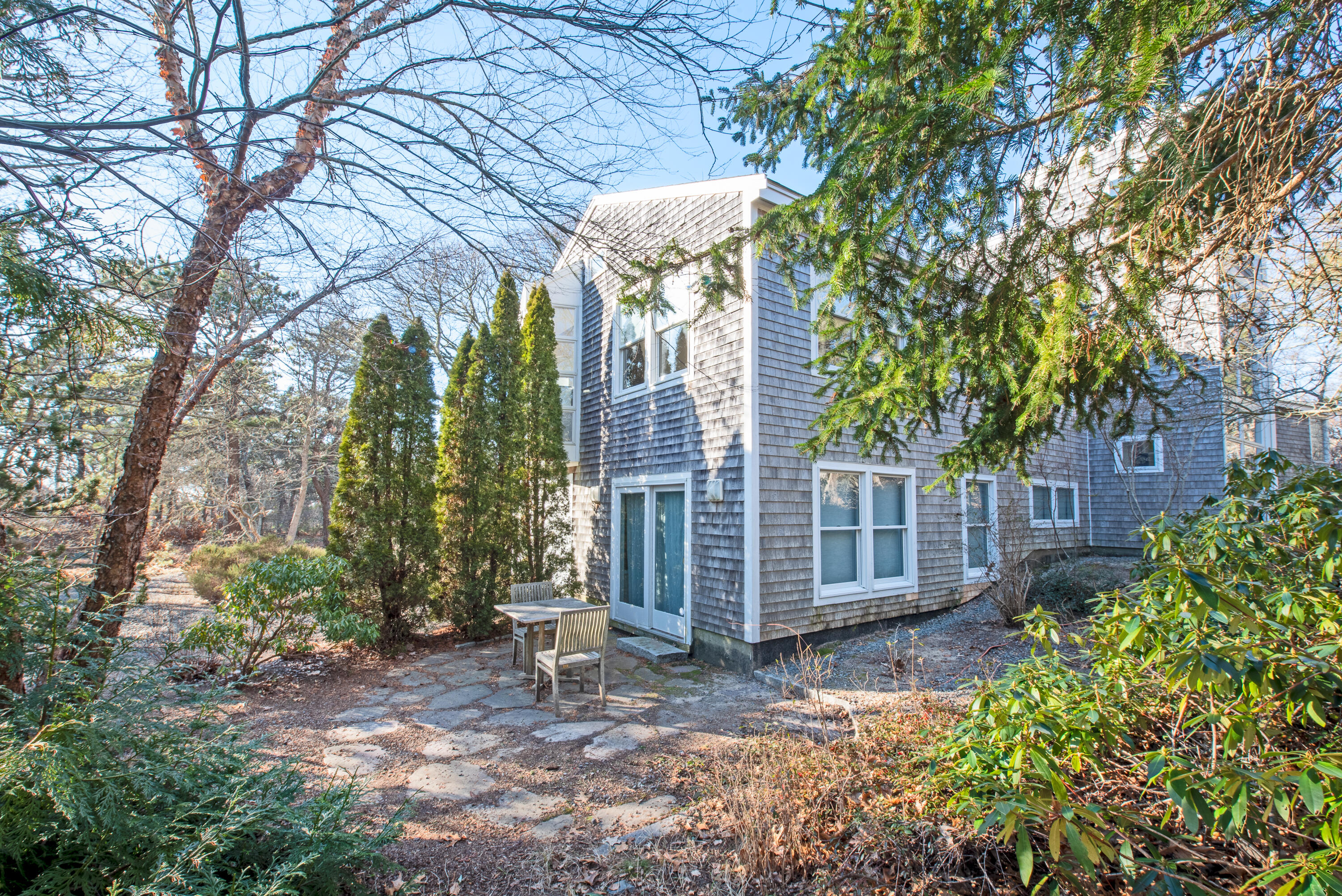 80 Shurtleff Road Eastham, MA 02642 - Photo 3 of 34 a view of a backyard with large trees and wooden fence