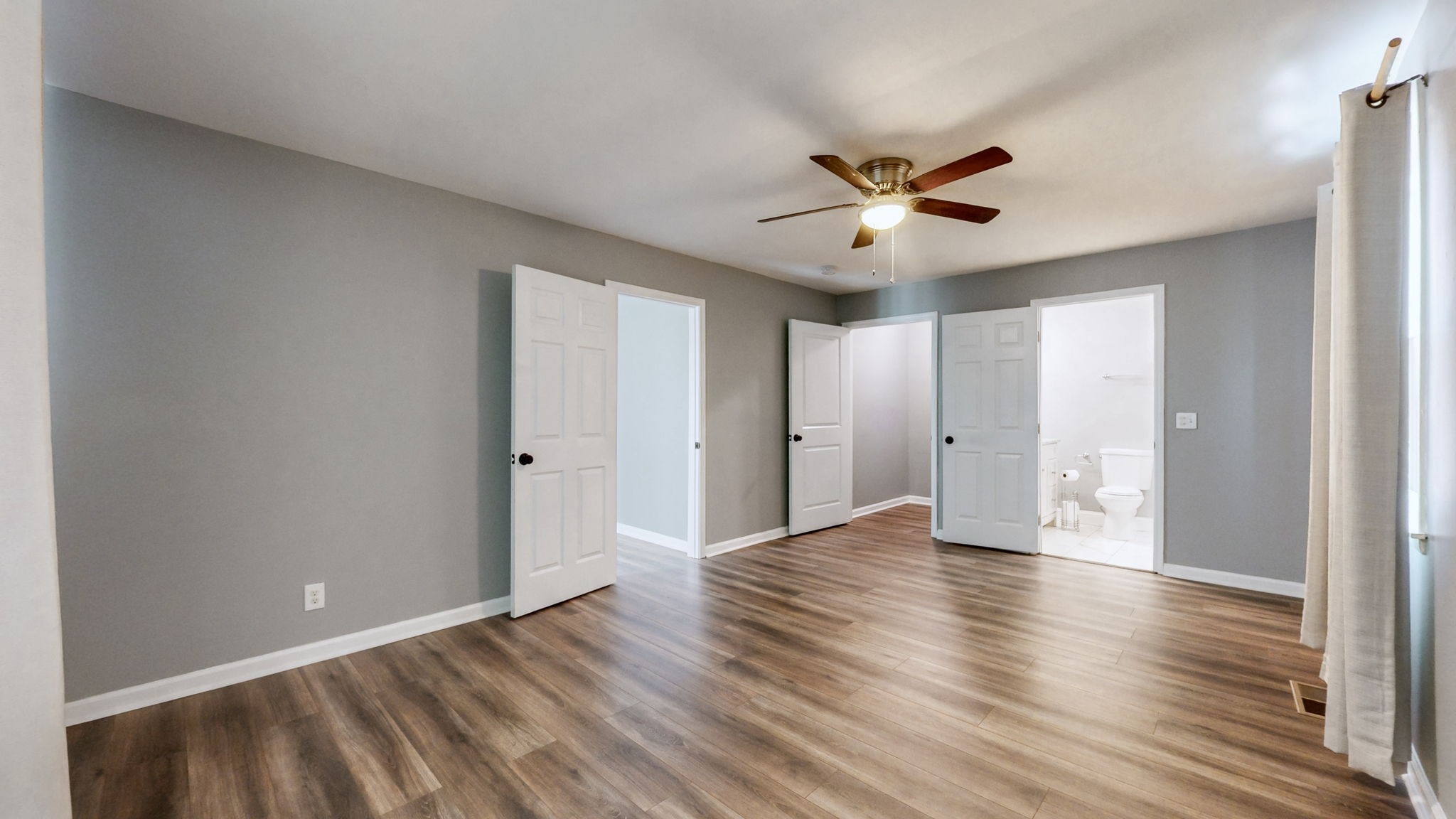 1214 Rutherford Street Murfreesboro, TN 37130 - Photo 15 of 37 a view of an empty room with wooden floor and a ceiling fan