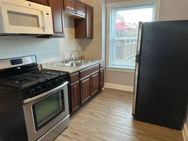 a kitchen with stainless steel appliances a stove a microwave and cabinets