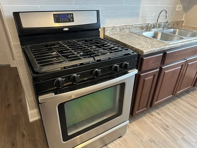 a stove top oven sitting inside of a kitchen