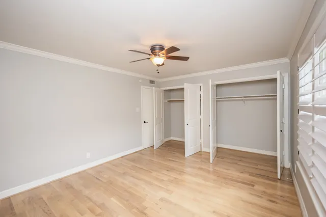 a view of a room with a ceiling fan and hardwood floor