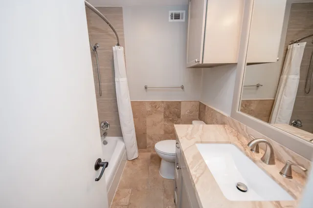 a bathroom with a sink a toilet and a shower