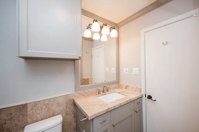 a bathroom with a granite countertop sink and a mirror