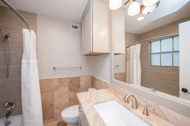 a bathroom with a sink a toilet and a mirror